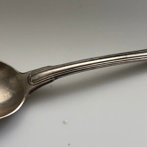 Peut inclure: Une cuillère en argent avec un bol arrondi et un design simple et élégant. La cuillère a un manche légèrement incurvé avec une extrémité arrondie.
