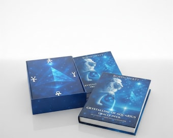 May include: A blue box and two books with a celestial design. The box and books feature a blue background with a geometric design and the text "Crystalline of Aquarius Oracle Deck". The books also feature a lion.