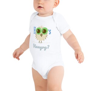 May include: White baby onesie with a cartoon owl design. The owl has large green eyes and is perched on a line. The text "Hoo's Hungry?" is printed above and below the owl in blue.