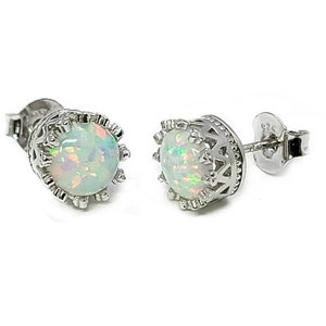 May include: A pair of silver stud earrings with a white opal gemstone set in a crown-shaped design.
