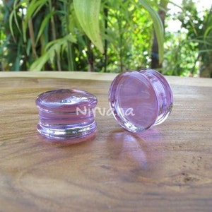 以下が含まれることがあります： 2つの紫色のガラス製のイヤーゲージ。1つはシングルフレアプラグ、もう1つはダブルフレアプラグです。