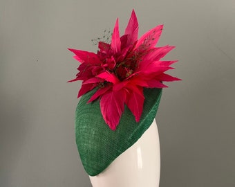 Béret perchoir vert orné d'une fleur en plumes fuchsia.