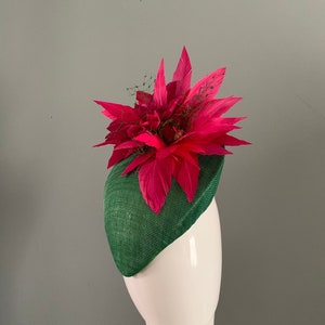 Grüne Baskenmütze, geschmückt mit einer fuchsiafarbenen Federblume. Bild 1