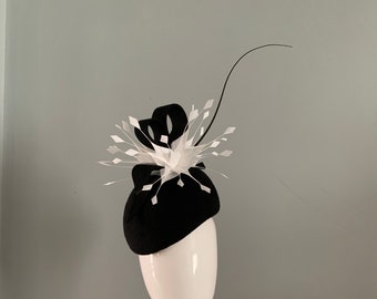 Black wool felt perching beret hat adorned with ivory feather flower sculptured loops and dramatic curled quill