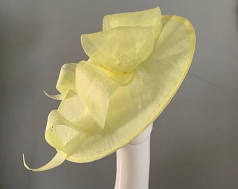 Large Lemon saucer hat / fascinator adorned with a sculptured bow with headband attachment.