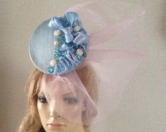pale blue silk abaca 3d pod hat adorned with chunky jewells & pearls finished with a pale pink crin sculpture.