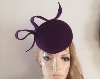 purple / plum wool felt perching hat adorned with a sculptured wave detail.