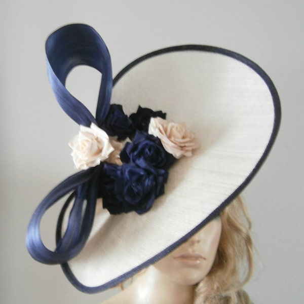 hand crafted almond sinamay twister edged in a navy trim embellished with silk flowers & bow