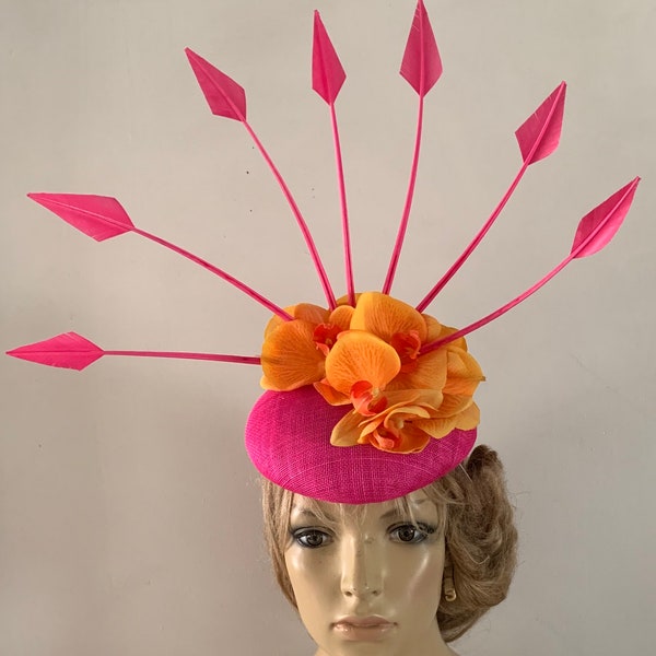 Hot pink perching beret hat adorned with a halo of dramatic arrow head feathers & silken orchid orange flowers.