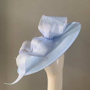 Large Pale Blue  saucer hat / fascinator adorned with a sculptured bow with headband attachment.