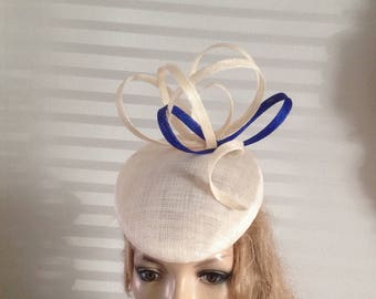 cream sinamay perching pillbox hat adorned with a splash of royal blue
