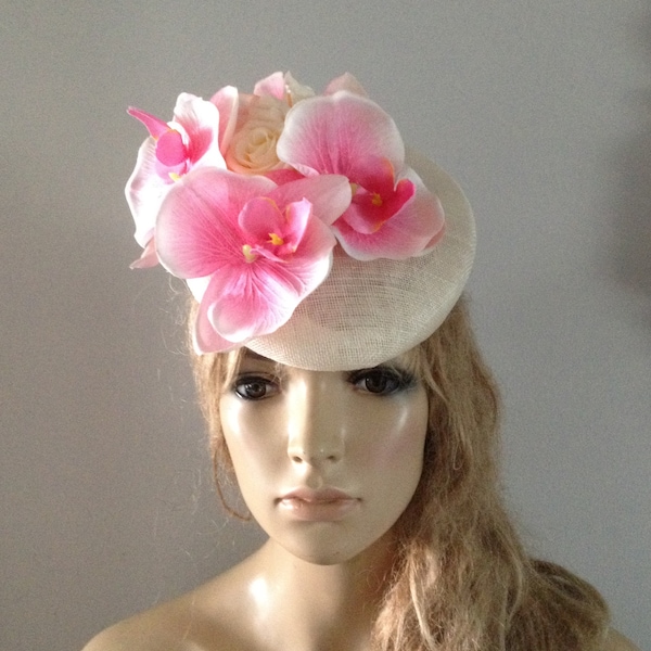 Chapeau de béret perché en ivoire orné d’orchidées et de roses soyeuses rose pâle.