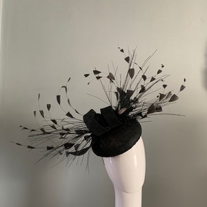 Black perching beret hat fascinator adorned with sprays of hand cut feathers and silken flowers.