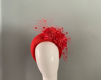 May include: A coral red headband with a large coral red flower and netting.