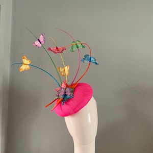 Fuchsia sinamay perching beret hat adorned with multi coloured quills & feather butterflies.