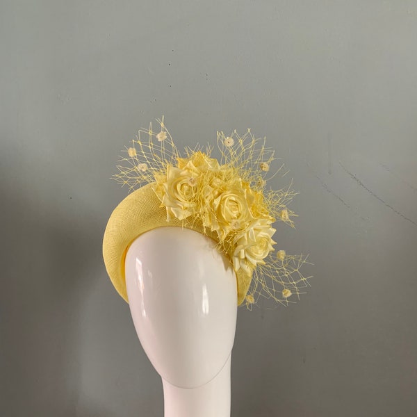 Yellow crown perching hat fascinator adorned with silken flowers and merry widow veiling.