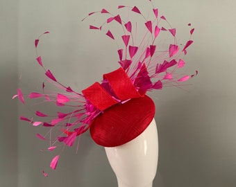 Red sinamay perching beret hat with sculptured loops silken fuchsia flowers hand cut feather details.