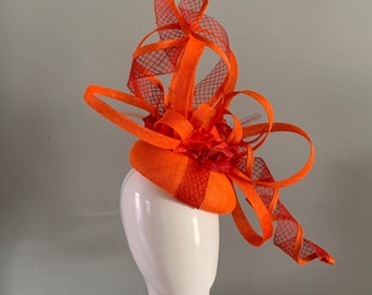 orange / red 2/3rds beret percher embellished with magnificent sculptured loops,diamond crin twists,silken flowers & feathers.