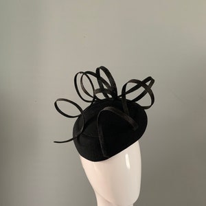 Black wool felt perching beret hat adorned with sculptured ribboned detail.