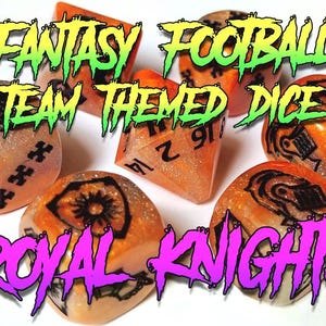 Op de afbeelding: Oranje en zwarte fantasy football team-thema dobbelstenen met glitter. De dobbelstenen zijn genummerd en hebben een ontwerp van een ridderhelm. De tekst "ROYAL KNIGHTS" staat in roze en groene letters.
