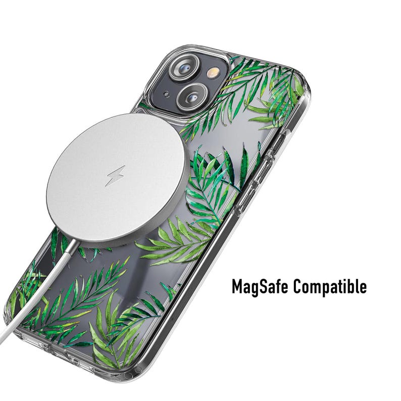 May include: Clear phone case with a green palm leaf design and a silver MagSafe charger attached. The case is labeled "MagSafe Compatible". The phone case is designed to protect the phone while allowing wireless charging.