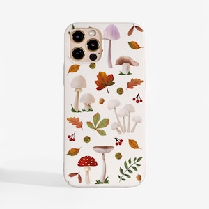 May include: A white smartphone case featuring a repeating pattern of various mushrooms, autumn leaves, small acorns, and red berries. The design includes a prominent red and white spotted mushroom, several pale fungi, and green foliage elements.