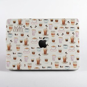 May include: A laptop skin featuring a repeating watercolor pattern of various coffee cups, mugs, and scattered coffee beans on a white background. The text "But first... COFFEE" is printed in a script font on the left side of the laptop cover.