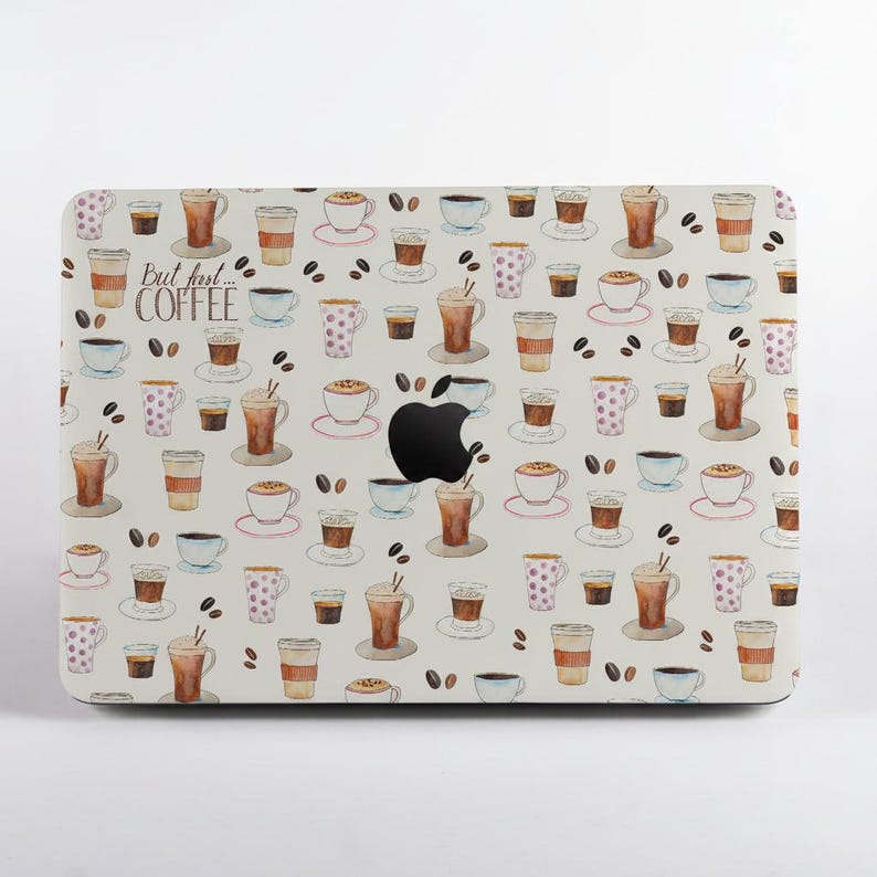 May include: A laptop skin featuring a repeating watercolor pattern of various coffee cups, mugs, and scattered coffee beans on a white background. The text "But first... COFFEE" is printed in a script font on the left side of the laptop cover.