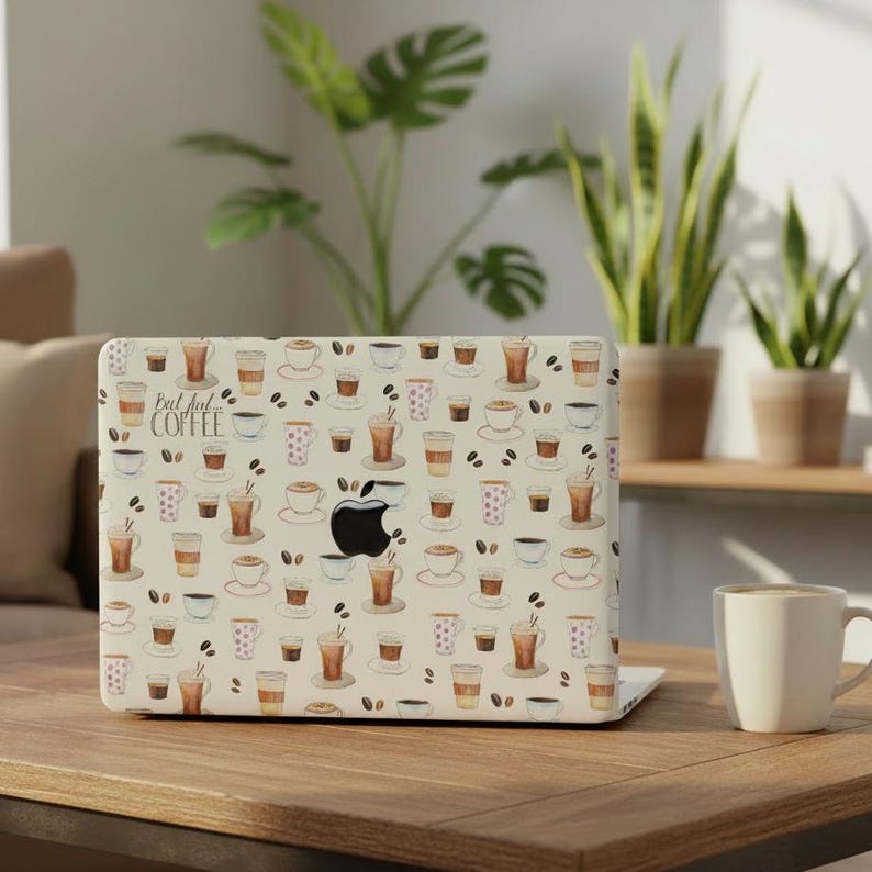 May include: A laptop skin featuring a repeating pattern of various coffee cups, mugs, and scattered coffee beans on a cream background. The text "But first... COFFEE" is printed in a dark script font on the left side of the laptop cover.