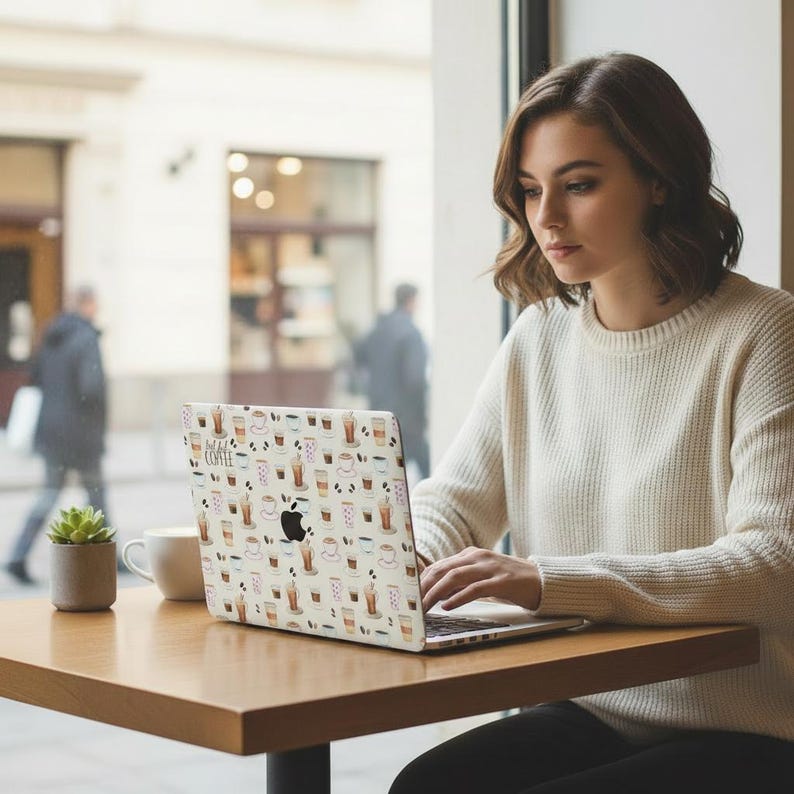 May include: A laptop skin featuring a repeating pattern of various coffee drinks in cups and mugs on a light background. The design includes small illustrations of lattes, cappuccinos, and espresso, with the text "but first coffee" printed in black.