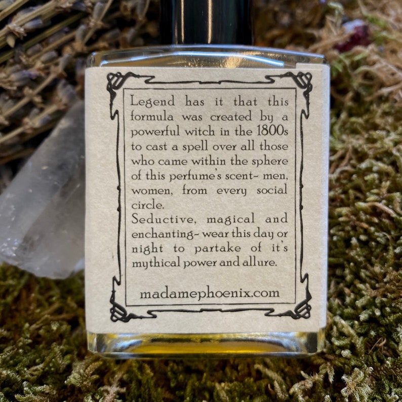 May include: A small glass bottle with a label that reads "Legend has it that this formula was created by a powerful witch in the 1800s to cast a spell over all those who came within the sphere of this perfume's scent- men, women, from every social circle. Seductive, magical and enchanting-wear this day or night to partake of it's mythical power and allure. madamephoenix.com"