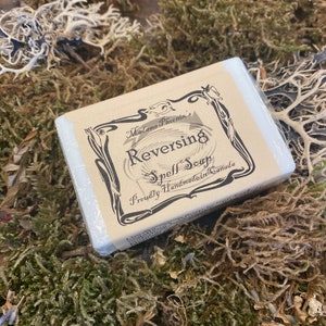 May include: A white bar of soap with a brown label that reads "Madame Phoenix's Reversing Spell Soap" and "Proudly Handmade in Canada".