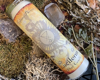 May include: A white candle with a yellow and gold label that says "Luciferus Altar Candle" and features a pentagram symbol. The candle is surrounded by dried herbs and a clear crystal.