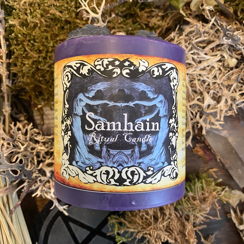 May include: Purple candle with a black wax top and a label that says "Samhain Ritual Candle". The label features a vintage-style illustration of two figures.
