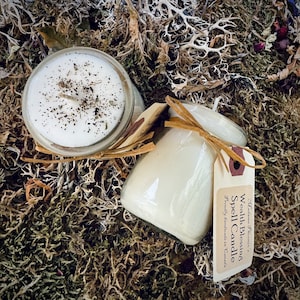 May include: Two glass candle jars with white wax and a brown label. The label reads "Wealth Blessing Spell Candle" and "Proudly handmade in Canada".