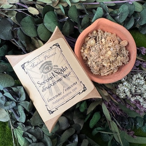 May include: A brown cardboard pillow box with a label reading Madame Phoenix Second Sight deuxième vue incense / encens madamephoenix.com and a terracotta bowl filled with a granular, light brown herbal incense blend.