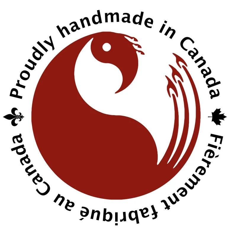 Puede incluir: Un logotipo circular con un gr&aacute;fico de p&aacute;jaro estilizado de color rojo oscuro en el centro. El texto Proudly handmade in Canada est&aacute; arqueado en la parte superior, mientras que Fi&egrave;rement fabriqu&eacute; au Canada est&aacute; en la inferior, con una flor de lis y una hoja de arce.