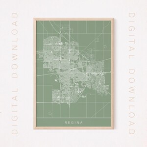 May include: A printable map of Regina, Saskatchewan, with a green background and white lines showing the city streets. The map is framed in a light wood frame. The text "Regina" is printed at the bottom of the map.