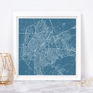 Puede incluir: Una impresión enmarcada de un mapa de la ciudad. El mapa es un dibujo lineal blanco detallado sobre un fondo verde azulado. La impresión está en un marco blanco. El mapa es de una ciudad con carreteras, edificios y otras características.