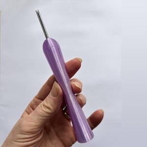 May include: A lavender-coloured tool with a metal needle tip. The handle has a textured, ridged design. The tool is held against a white background.