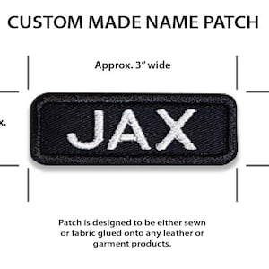 May include: Black fabric patch with white embroidered text "JAX". The patch is approximately 3 inches wide and 1 inch tall.