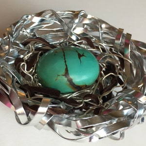 Turquoise egg in metal nest
