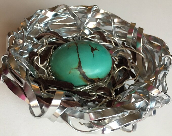 Turquoise egg in metal nest