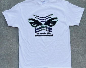 May include: White t-shirt with a green and black graphic print of a pair of eyes and the text "The Great American Music Hall and Parsley Productions Present Paradise Waits November 11 & 12, 1988 The Blues for Allah 20th Anniversary Concert"