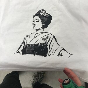 Peut inclure: Illustration en noir et blanc d'une femme en kimono japonais traditionnel avec une fleur dans les cheveux.
