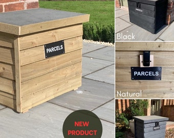 Può includere: Una cassetta di legno per pacchi con un coperchio incernierato e un cartello nero che dice "PARCELS". La cassetta è disponibile in tre colori: naturale, nero e grigio.