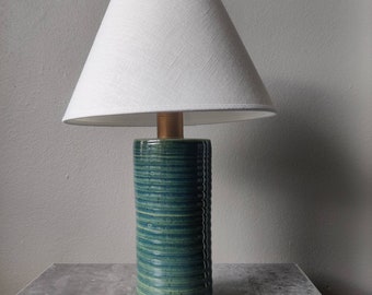 Green  little bedside lamp. Goes nicely on the deck top too. Finnish hand made pottery table lamp. Natural White Swedish clip on shade.