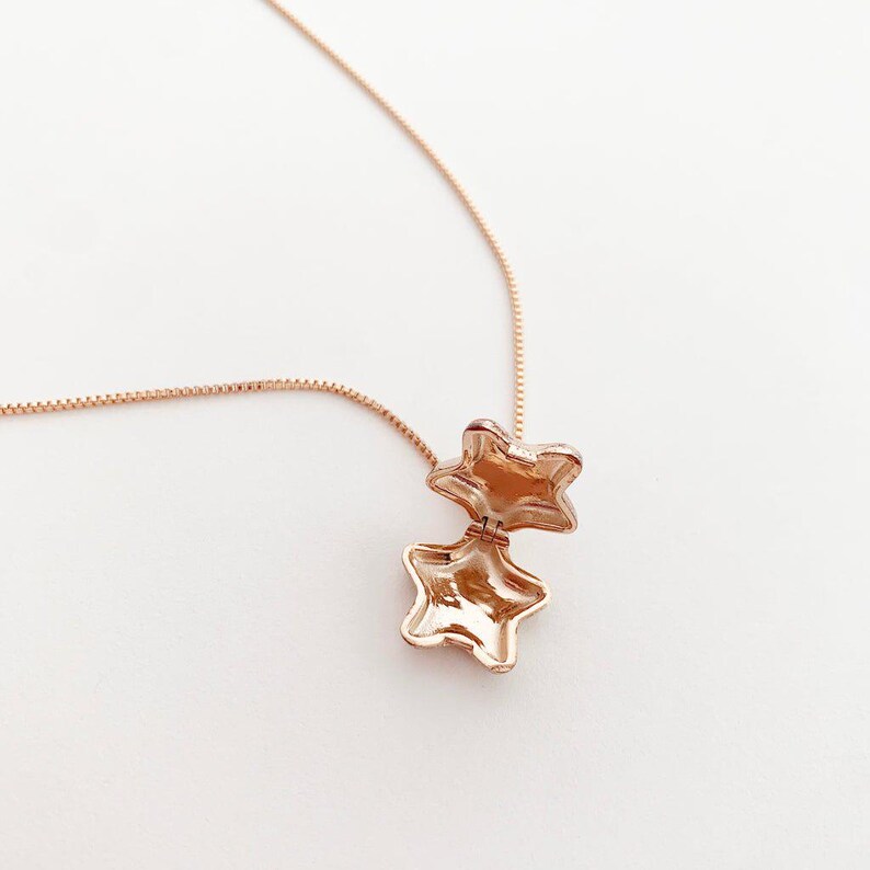 Close-up of the Polly Star Locket Necklace showcasing a star charm that opens, perfect for layering and styling.