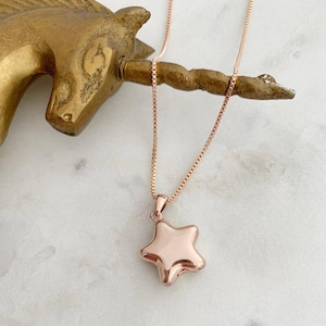 Polly Star Locket Necklace on a gold unicorn figurine, showcasing its charm and adjustable chain.
