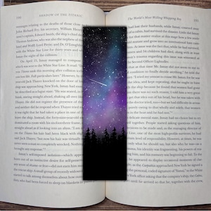 May include: A close-up of a book with a bookmark featuring a galaxy with a shooting star. The book is open to a page with the title "Shadow of the Titanic" and text about the sinking of the Titanic.